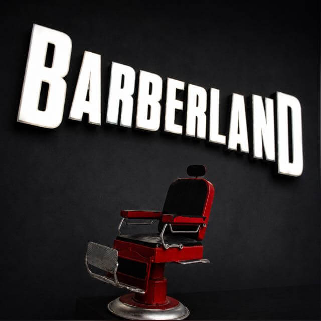 Sillón vintage bajo el rótulo luminoso de Barberland Premium